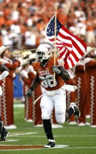 A football player running with the american flag.
